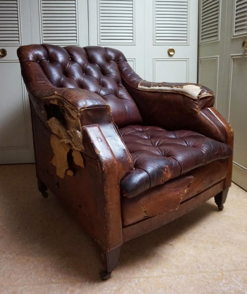 Distressed leahter library armchair with buttoned back and seating earea